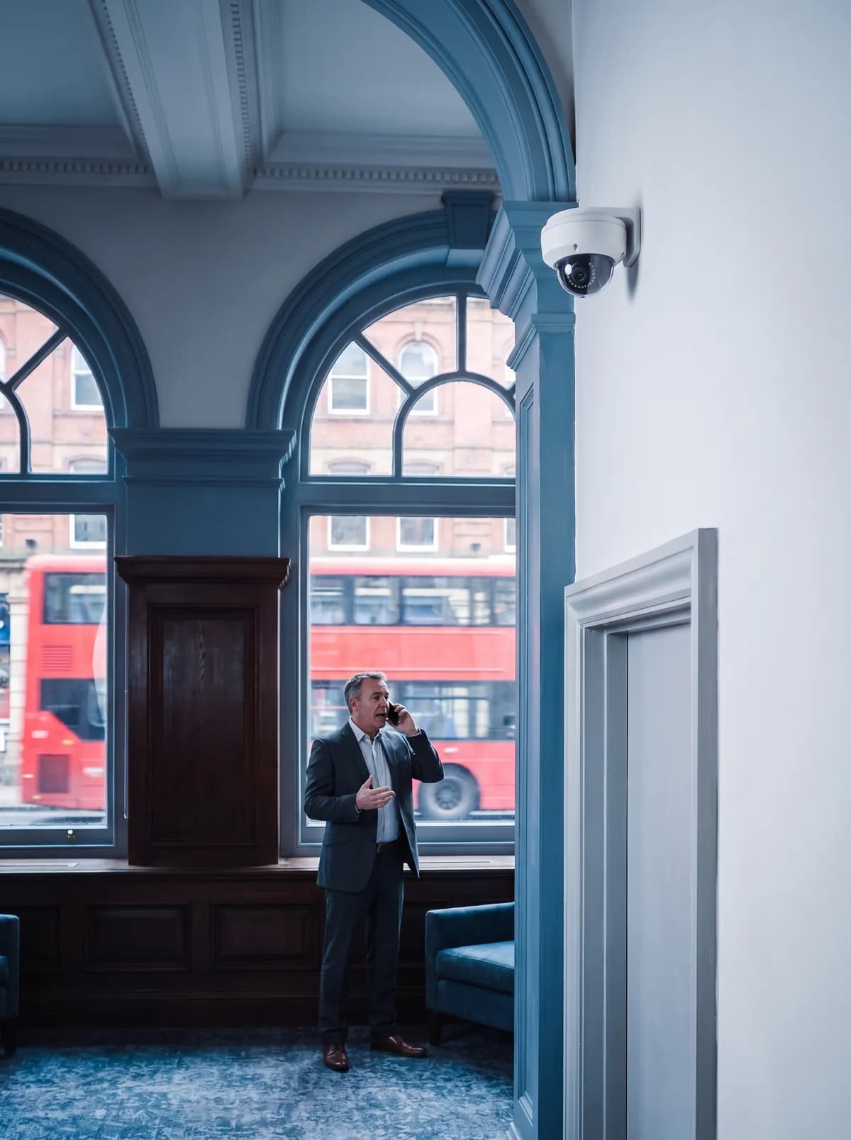 Person making a phone call in a room with a ceiling-mounted camera