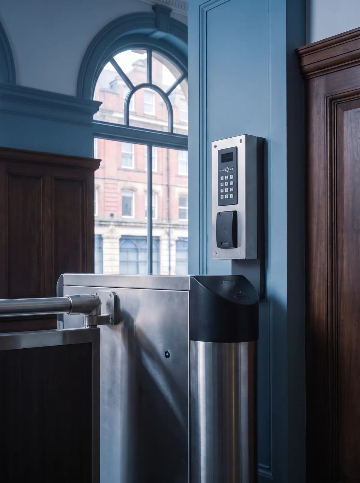 Entry reader beside a pedestrian gate in an entrance hall