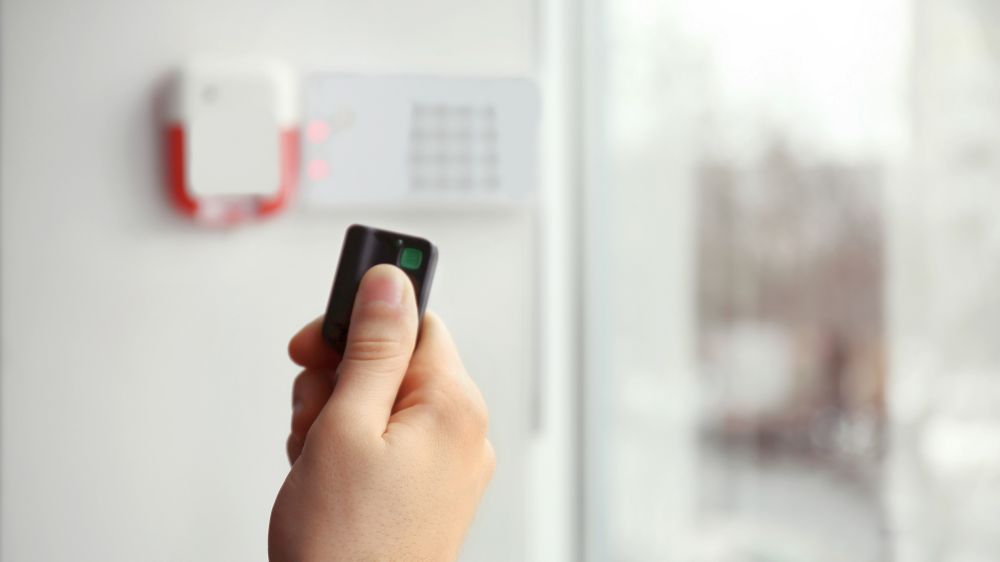 Security alarm keypad with male hand button closeup